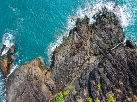 Rugged rock outcrop surrounded by clear turquoise water off Koh Chang.