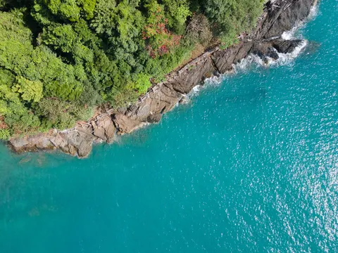 Waves breaking along a steep forested stretch of the Koh Chang coast.