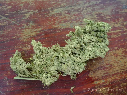 Loose dried Koh Chang cannabis flowers laid on a wooden table.