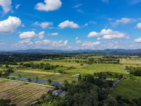 A patchwork of fields, ponds and tree lines across a wide valley floor.